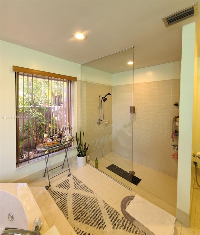 bathroom featuring tile patterned flooring and shower with separate bathtub