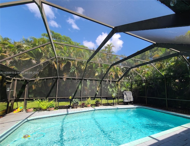 view of swimming pool featuring a lanai