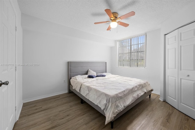 bedroom featuring ceiling fan, hardwood / wood-style flooring, a closet, and a textured ceiling