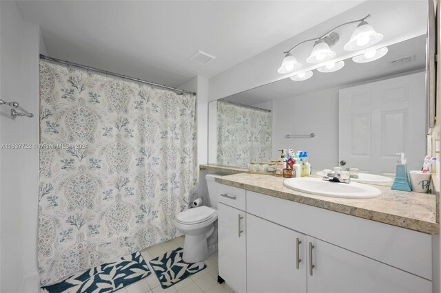 bathroom featuring tile patterned floors, toilet, vanity, and a shower with curtain