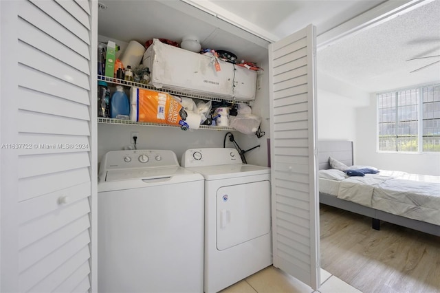 washroom with a textured ceiling, light hardwood / wood-style floors, and independent washer and dryer