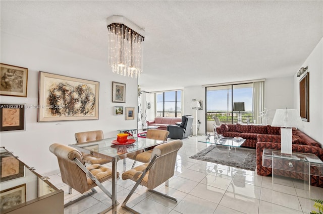 dining area with a notable chandelier, light tile patterned floors, and a textured ceiling