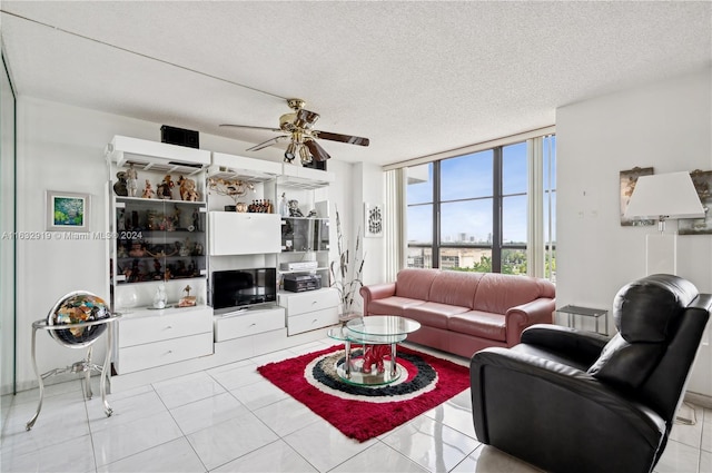 tiled living room featuring expansive windows, a textured ceiling, and ceiling fan