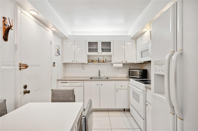 kitchen with sink, white cabinetry, light tile patterned floors, and white appliances