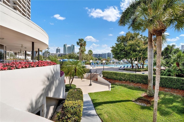 view of community featuring a swimming pool, a lawn, and a patio area