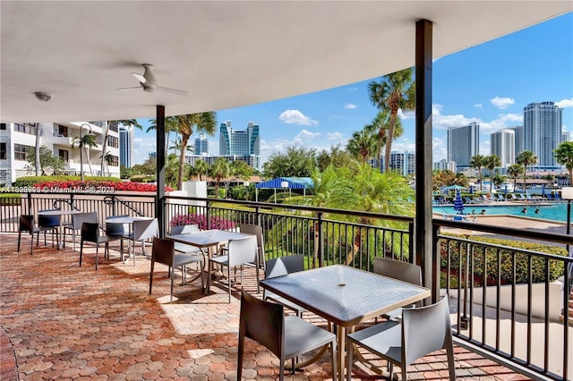 view of patio / terrace with a balcony, a community pool, and ceiling fan