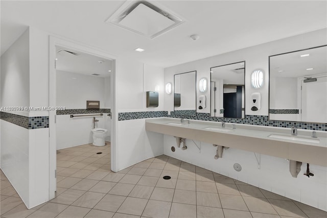 bathroom with tasteful backsplash, a bidet, tile walls, dual vanity, and tile patterned floors