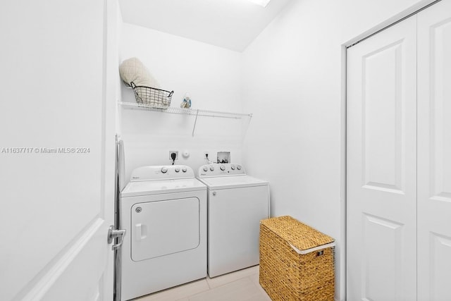 washroom with washer and clothes dryer and light tile patterned floors