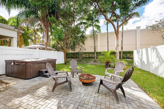 view of patio / terrace with a hot tub and a fire pit