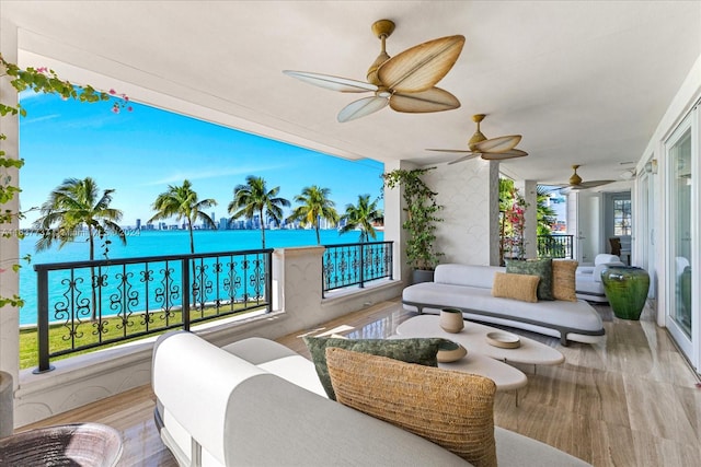 balcony with an outdoor hangout area, a water view, and ceiling fan