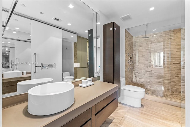 bathroom with tile patterned flooring, vanity, toilet, and a shower with shower door