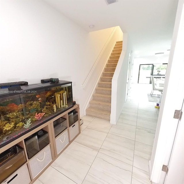 stairway featuring light tile patterned floors