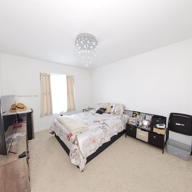 bedroom with light carpet and a chandelier