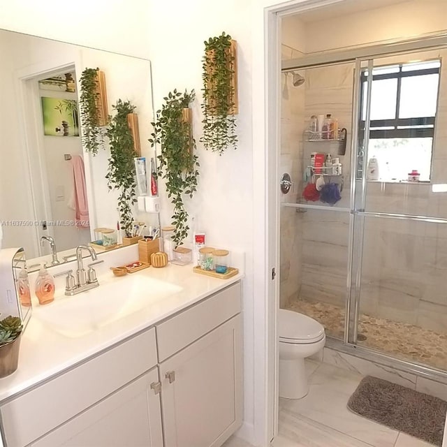 bathroom featuring tile patterned floors, vanity, walk in shower, and toilet