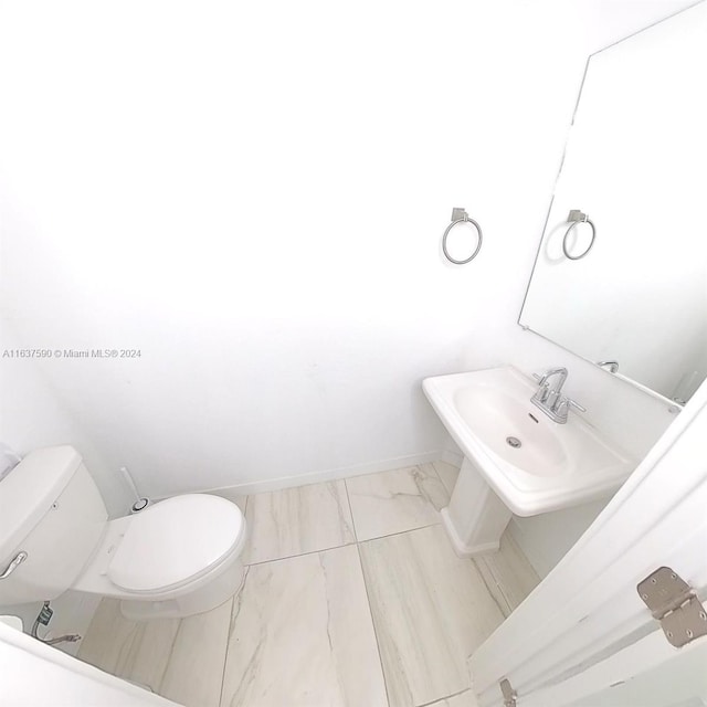 bathroom featuring sink, toilet, and tile patterned flooring