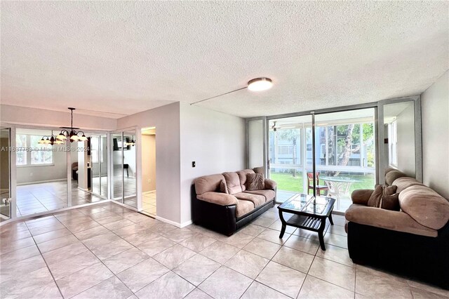 living room featuring a textured ceiling, an inviting chandelier, and light tile patterned floors