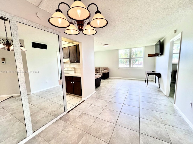 interior space with a textured ceiling and light tile patterned flooring