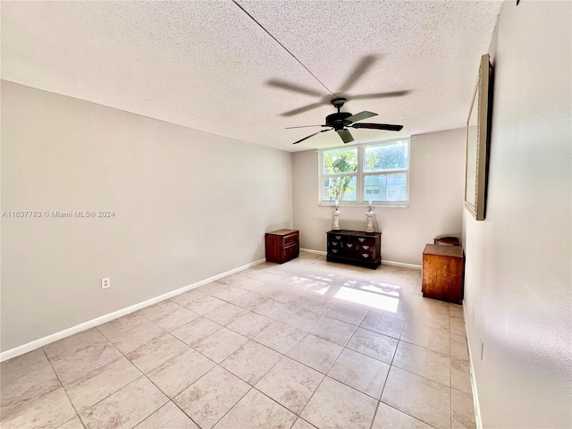 unfurnished bedroom with a textured ceiling, ceiling fan, and light tile patterned floors