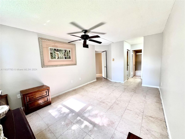 unfurnished bedroom featuring a textured ceiling, ceiling fan, and light tile patterned floors