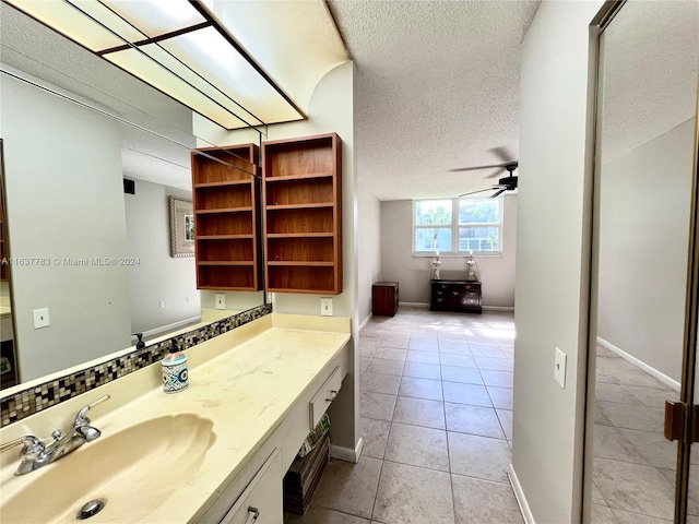 bathroom with tile patterned flooring, ceiling fan, a textured ceiling, and vanity