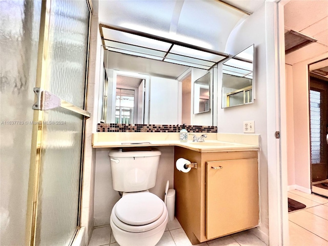 bathroom with a shower with door, toilet, tile patterned flooring, and vanity