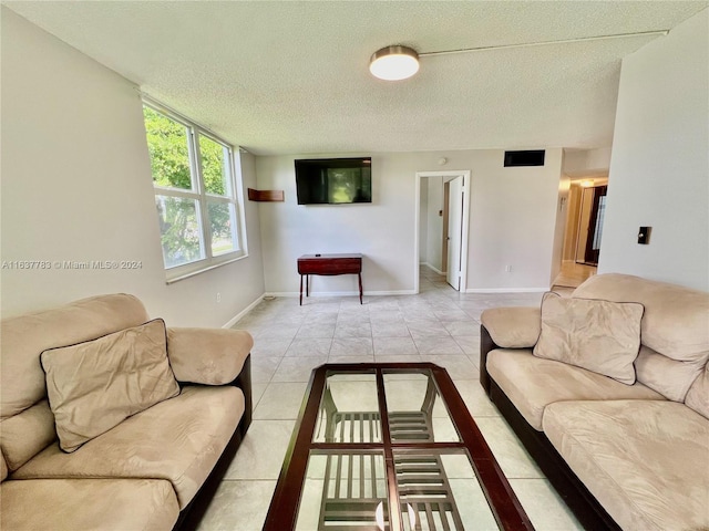 tiled living room featuring a textured ceiling