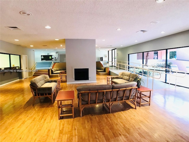 living room with a textured ceiling and light hardwood / wood-style floors