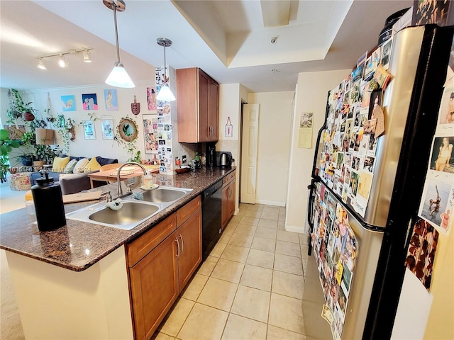 kitchen featuring sink, decorative light fixtures, fridge, a tray ceiling, and black dishwasher