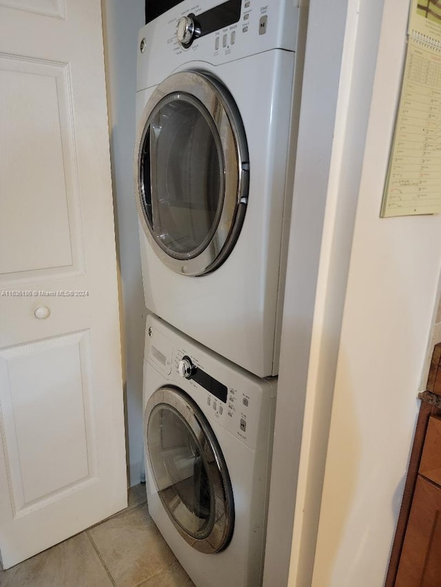 laundry room featuring light tile patterned floors and stacked washer and clothes dryer