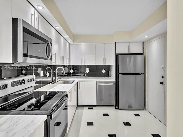 kitchen with sink, appliances with stainless steel finishes, backsplash, and light tile patterned floors