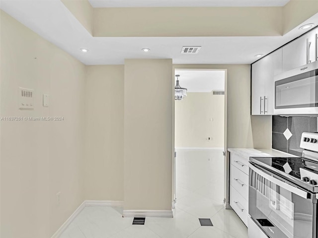 kitchen with tasteful backsplash, light tile patterned floors, and electric stove