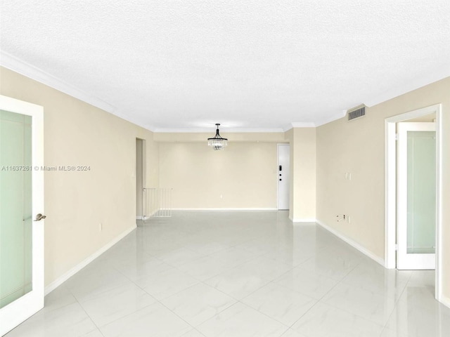 spare room with light tile patterned flooring, a textured ceiling, and ornamental molding