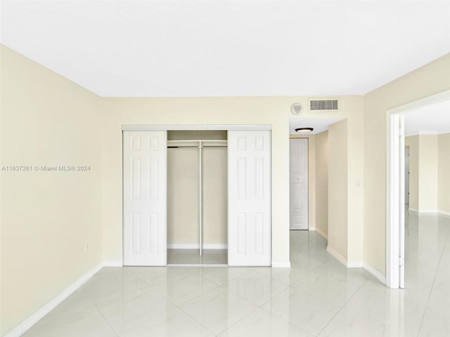 unfurnished bedroom with a closet and light tile patterned floors