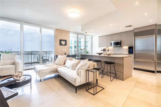 tiled living room featuring floor to ceiling windows