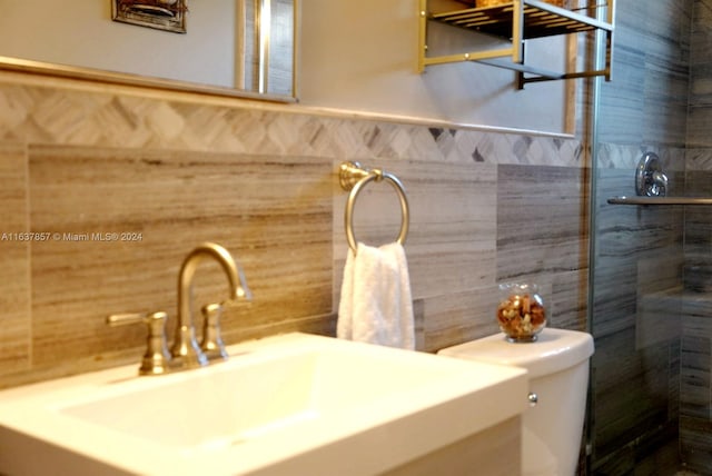 full bathroom with toilet, tile walls, vanity, and a tile shower