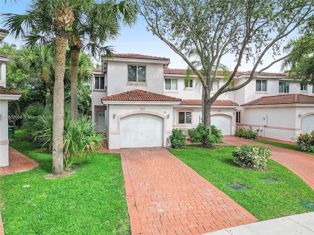 mediterranean / spanish home with decorative driveway, stucco siding, a tiled roof, a front yard, and a garage