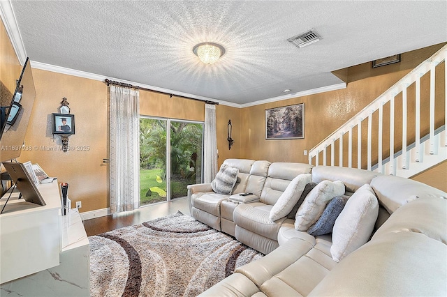 living room featuring ornamental molding, wood finished floors, stairway, a textured wall, and a textured ceiling
