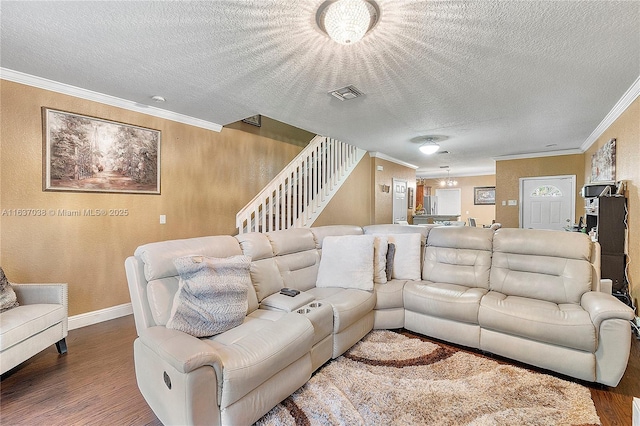 living room featuring wood finished floors, crown molding, a textured ceiling, baseboards, and stairs