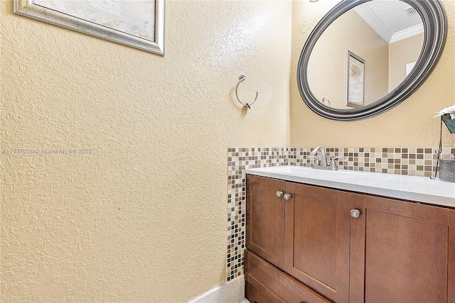 bathroom featuring tasteful backsplash, vanity, and ornamental molding