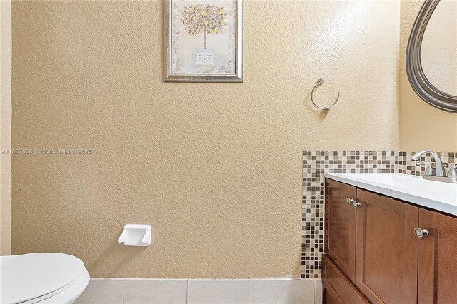 bathroom with vanity, tasteful backsplash, toilet, and tile patterned flooring