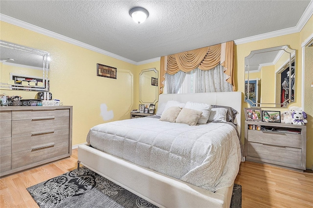 bedroom featuring light wood-type flooring, ornamental molding, and a textured ceiling