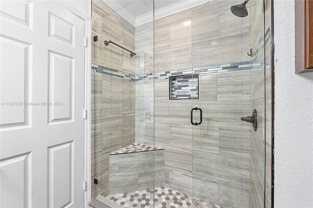 bathroom featuring a shower with shower door and crown molding