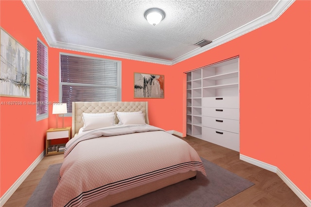 bedroom with a textured ceiling, ornamental molding, wood finished floors, and baseboards