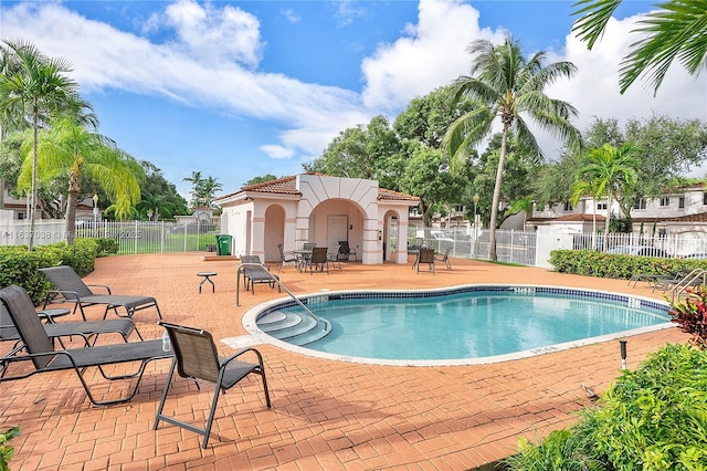 community pool with a patio and fence
