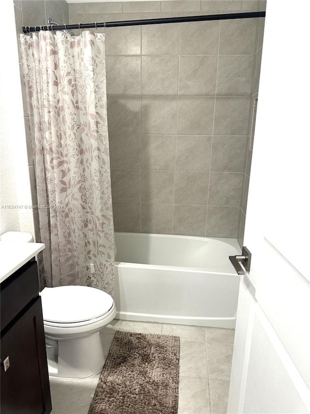 full bathroom featuring vanity, shower / bath combo with shower curtain, tile patterned flooring, and toilet