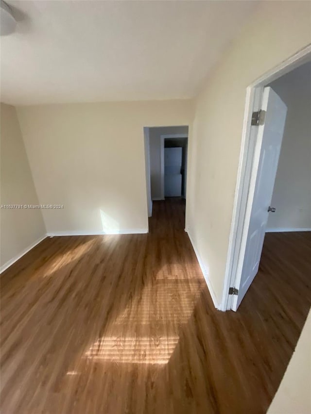 bonus room with lofted ceiling, a wall mounted AC, and dark hardwood / wood-style flooring