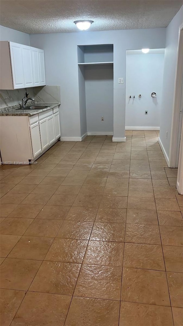 clothes washing area featuring stacked washing maching and dryer and light tile patterned floors