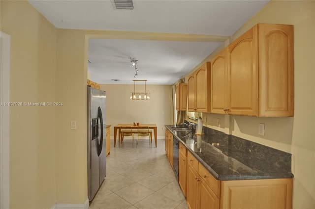 kitchen featuring stainless steel appliances, light brown cabinets, dark stone countertops, hanging light fixtures, and light tile patterned flooring