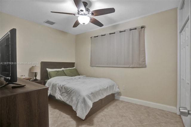 tiled bedroom featuring ceiling fan and a closet