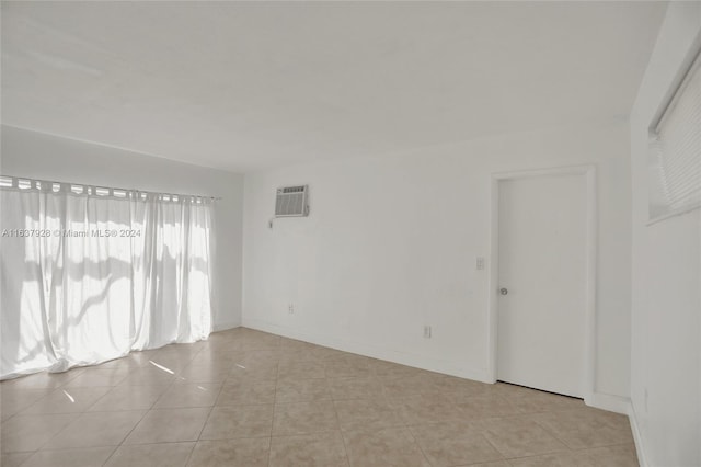 tiled spare room with an AC wall unit